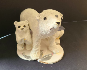 A sculpture of a polar bear, made from cardboard and white dish rags.